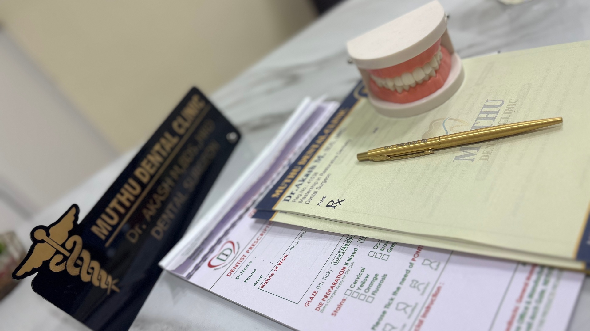 Dr. Akash M.'s consultation desk with Muthu Dental Clinic prescription pad